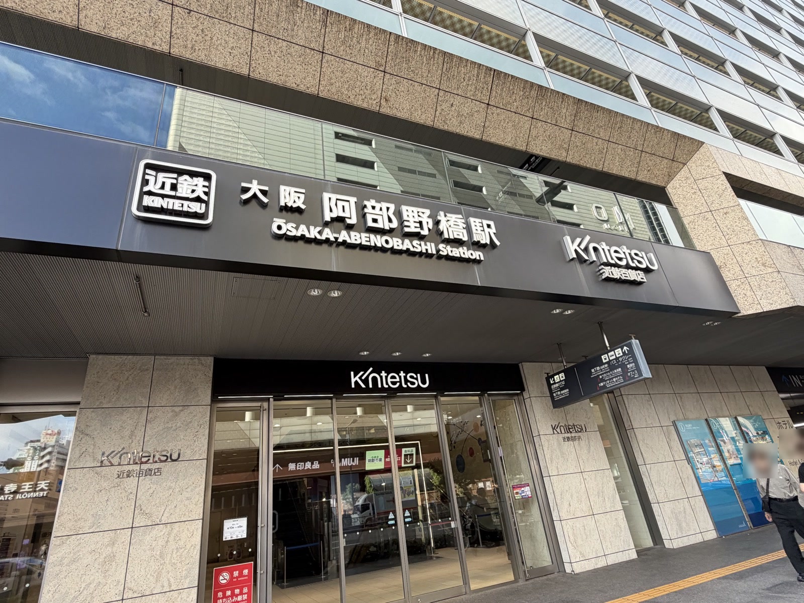 近鉄・大阪阿部野橋駅の外観。庇に「近鉄 大阪阿部野橋駅 OSAKA-ABENOBASHI Station」の看板が掲げられ、下は近鉄百貨店のガラス扉