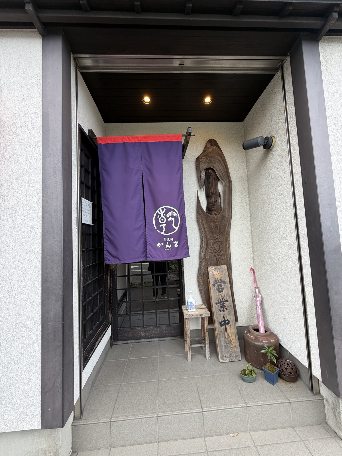 かん吉 清水店の紫ののれんと、営業中の木札