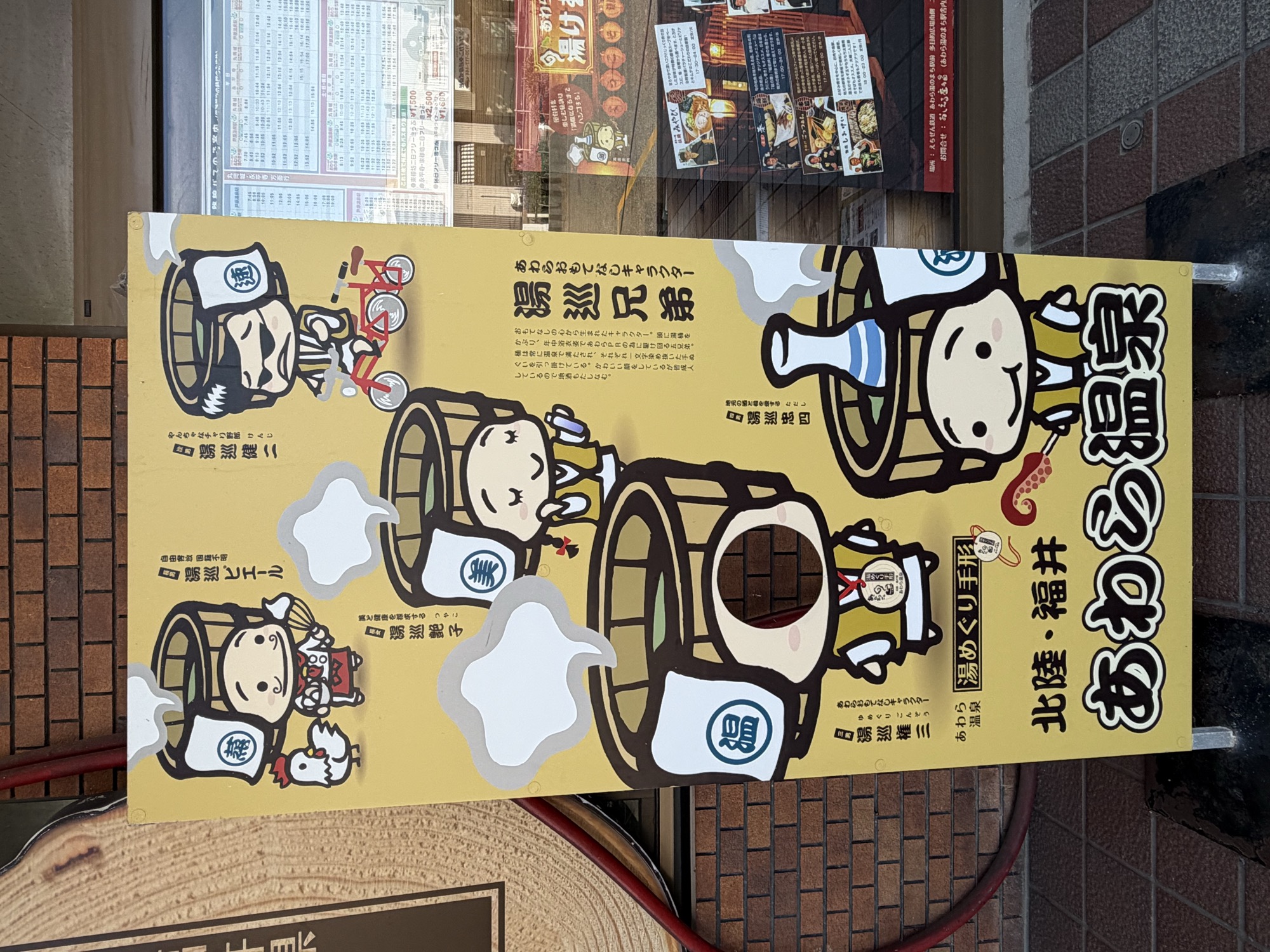 あわら温泉の湯めぐり手形を紹介するキャラクター案内板