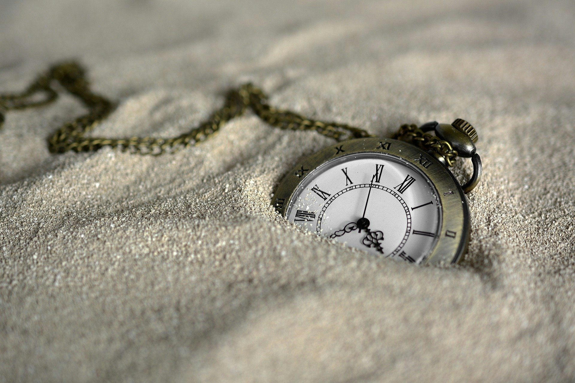 砂浜でうまっている懐中時計